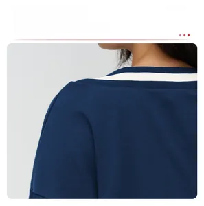 Detail of navy knit sweater showing white striped V-neck and dropped shoulder stitching