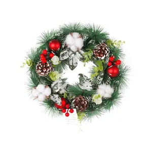 Christmas wreath with pine needles, cones, red berries, cotton and shiny ornaments