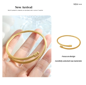 Detail of gold spiral cable cuff bracelet showing flexible open design and texture