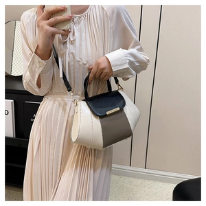 Chic tricolor crossbody bag shown on shoulder featuring black, white and khaki panels
