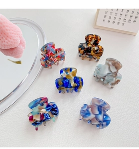 Set of 6 small acetate hair claws with marble and floral patterns on white background