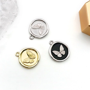 Detailansicht der runden Schmetterlingsanhänger aus Legierung in Gold, Silber und Schwarz