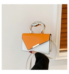 Detail of the orange and white color-block handbag with a silver irregular metal handle