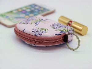Detail of pink floral fabric coin purse with zipper and key ring showing compact size