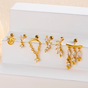 Detailed macro view of six gold-plated stud earrings with cubic zirconia on white display