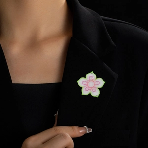 Detalle de broche de flor de 5 pétalos en solapa de blazer negro como accesorio decorativo