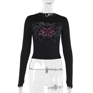 Dettaglio della stampa Outcast e grafica farfalla rosa su crop top nero a maniche lunghe