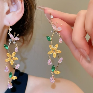 Close-up of model wearing zircon butterfly flower tassel earrings with colorful gemstones
