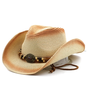 Handmade straw cowboy hat with ethnic beads and adjustable chin strap on white backdrop