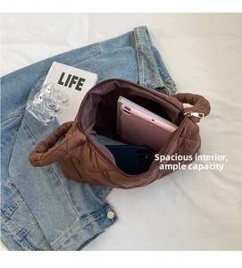 Brown quilted tote bag showing interior capacity with a tablet and smartphone inside