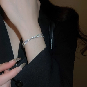 Gros plan d'un bracelet croisé double couche en argent avec des zircons brillants