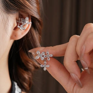Detailed close-up of a silver flower ear cuff featuring zircon stones and fringe tassels