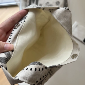 Close-up of cotton linen tote bag featuring metal magnetic buckle and off-white lining