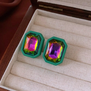 Macro detail of vintage octagonal earrings with iridescent crystal in green matte frame