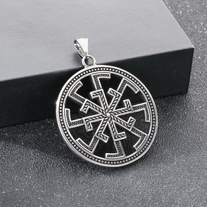 Macro detail of ancient silver Viking Kolovrat pendant on black gift box
