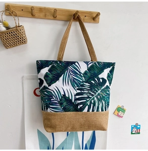 Detail of canvas tote bag with green leaf print and khaki linen bottom stitching