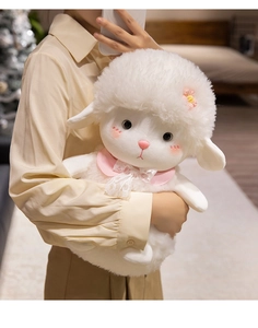 Detail of cute white plush lamb with pink lace bow and floral accent being held by a model
