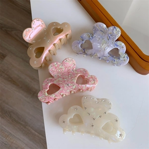 Elegant acetate hair claws with butterfly and heart designs featuring sparkling rhinestones
