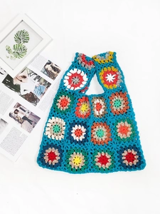 Detail shot of a handmade crochet tote bag featuring multi-colored granny square patterns