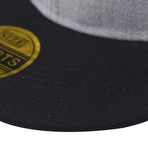 Macro detail of the grey fabric crown and black brim with gold size sticker on the cap