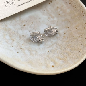 Macro shot of silver metal clip-on earring converters with clear silicone pads on ceramic