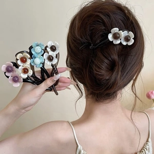 Close-up of elegant floral hair clips with pearlescent finish and dark center bead