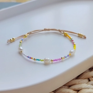 Detail of colorful Miyuki bead bracelet with freshwater pearls and adjustable cord