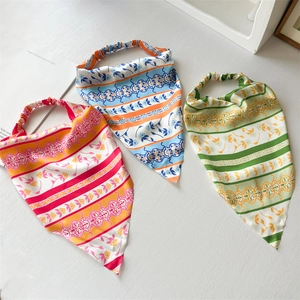 Three patterned satin triangle headscarves with elastic bands on white background