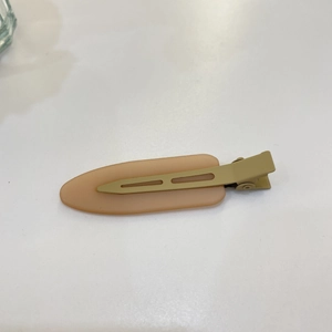 Detail view of the sleek matte nude and olive green traceless hair clip for women