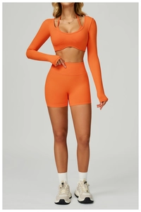 Detail of high-stretch seamless knit fabric on orange yoga crop top and shorts set