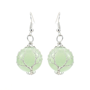 Detail of handmade silver wire wrapped tree of life earrings with green natural stone