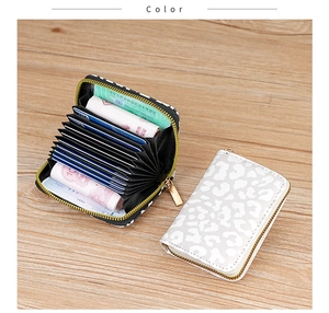 Detailed macro view of leopard print card holder with organ accordion slots and zipper