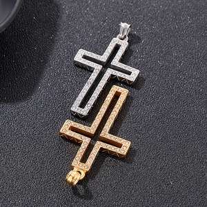 Close-up of hollow gold and silver cross pendants with shimmering rhinestones and metal details