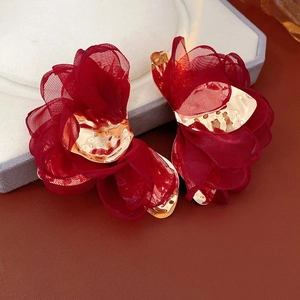 Macro view of wine red chiffon flower earrings with hammer-textured gold center petals