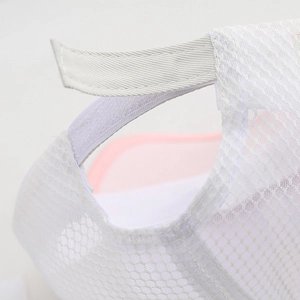 Detail of white mesh baseball cap showing breathable fabric and adjustable velcro strap