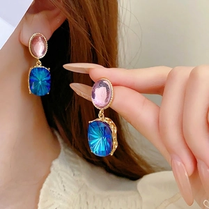 Vintage style gold earrings featuring pink oval gems and blue rectangular faceted drops