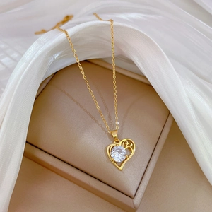 Elegant gold heart pendant necklace with round zircon on silk fabric display