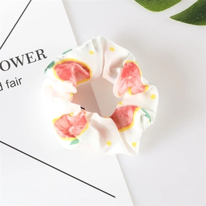 Close-up of white chiffon scrunchie featuring cute red watermelon and yellow polka dots