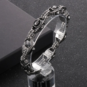Vista macro di bracciale punk con teschio vintage, finitura argento anticato e acciaio