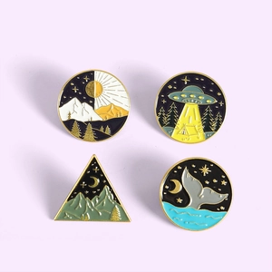 Detailed view of four creative enamel pins featuring whale tails and geometric nature scenes