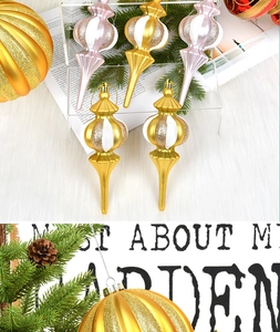 Detail of glittery gold and pink Christmas onion drop ornaments on festive pine branches
