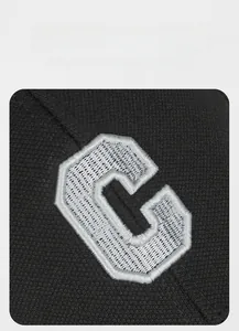 Detailed macro view of high-density 3D embroidery showing white letter C on black cotton cap
