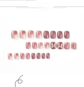 Detail of pink marble nails with 3D bows and pearls on white background