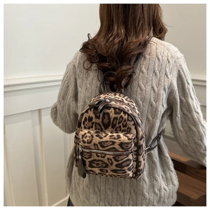 Mini leopard print backpack shown on a person for scale with soft lighting and cozy vibes