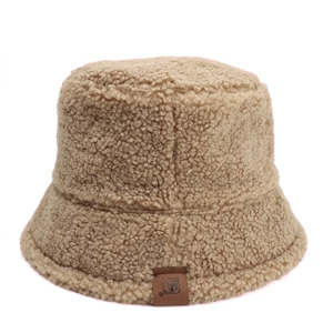 Detail of the warm khaki lamb wool texture and leather logo on the bucket hat