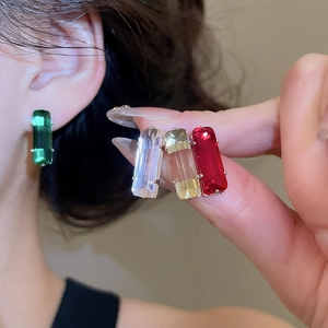 Detailed view of rectangular gemstone stud earrings in red, green, yellow and clear colors