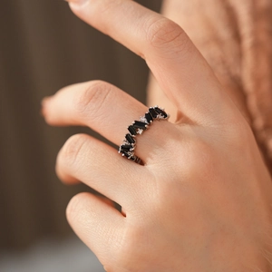 Detailed view of silver ring featuring alternating black baguette cut zircon stones