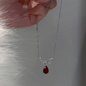 Silver chain necklace featuring a elegant red teardrop zircon pendant with wing detail