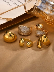 Detailed close-up of golden stainless steel rings with zircons on champagne satin