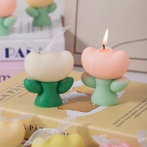 Minimalist tulip flower scented candles in pink and cream with ribbons on vintage books